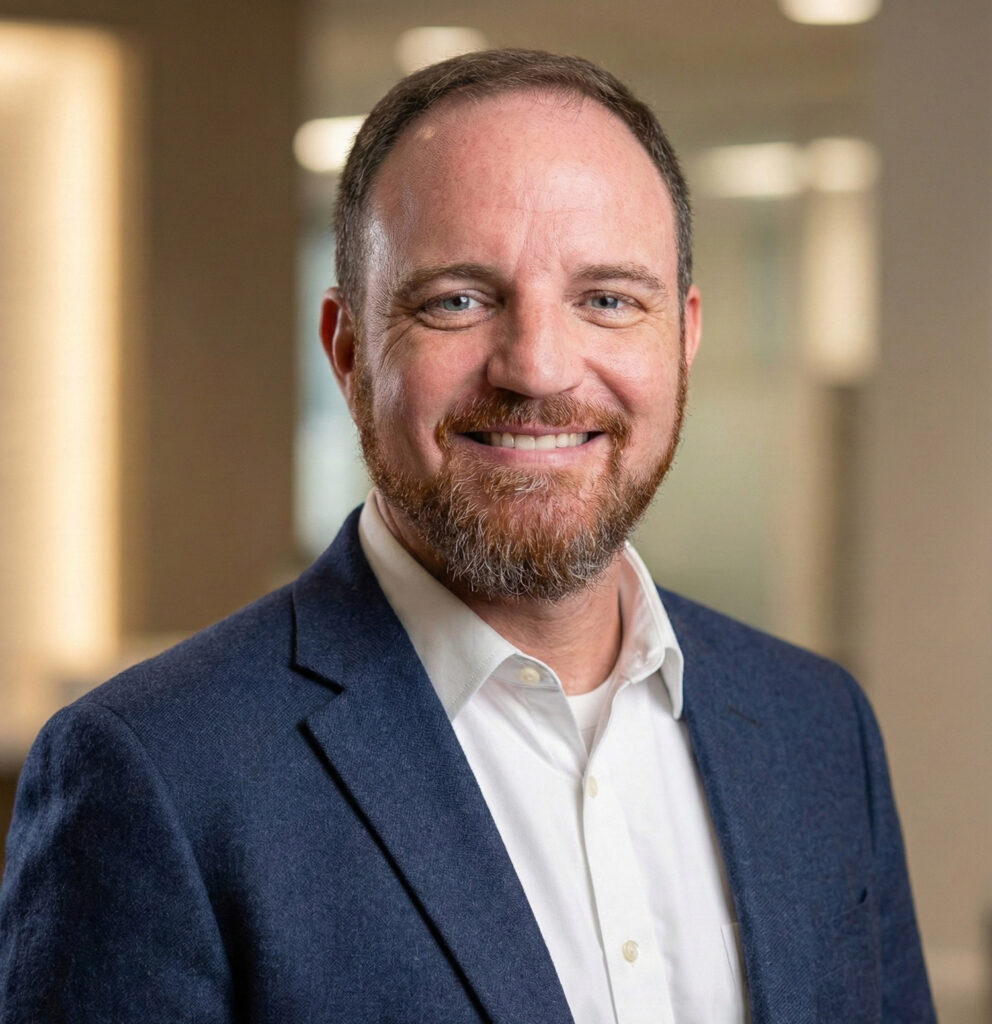Professional portrait of a smiling man in a blazer and white shirt, representing expertise in marketing and business solutions at Golden Path Digital.